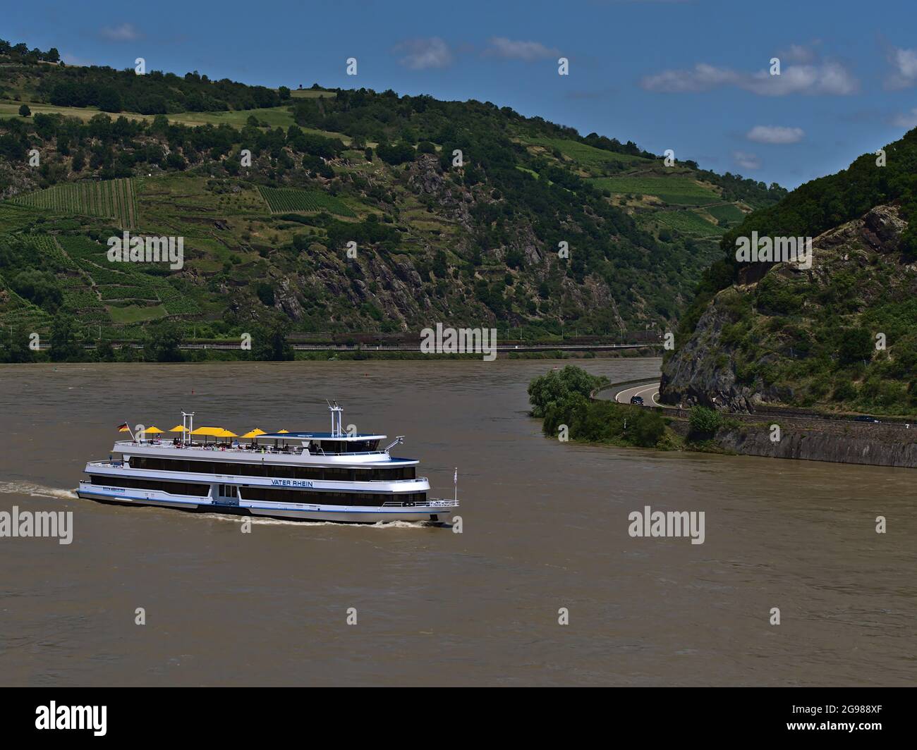 View of excursion passenger vessel Vater Rhein with tourists on deck enjoying the sunny day on Rhine river with beautiful landscape in summer season. Stock Photo
