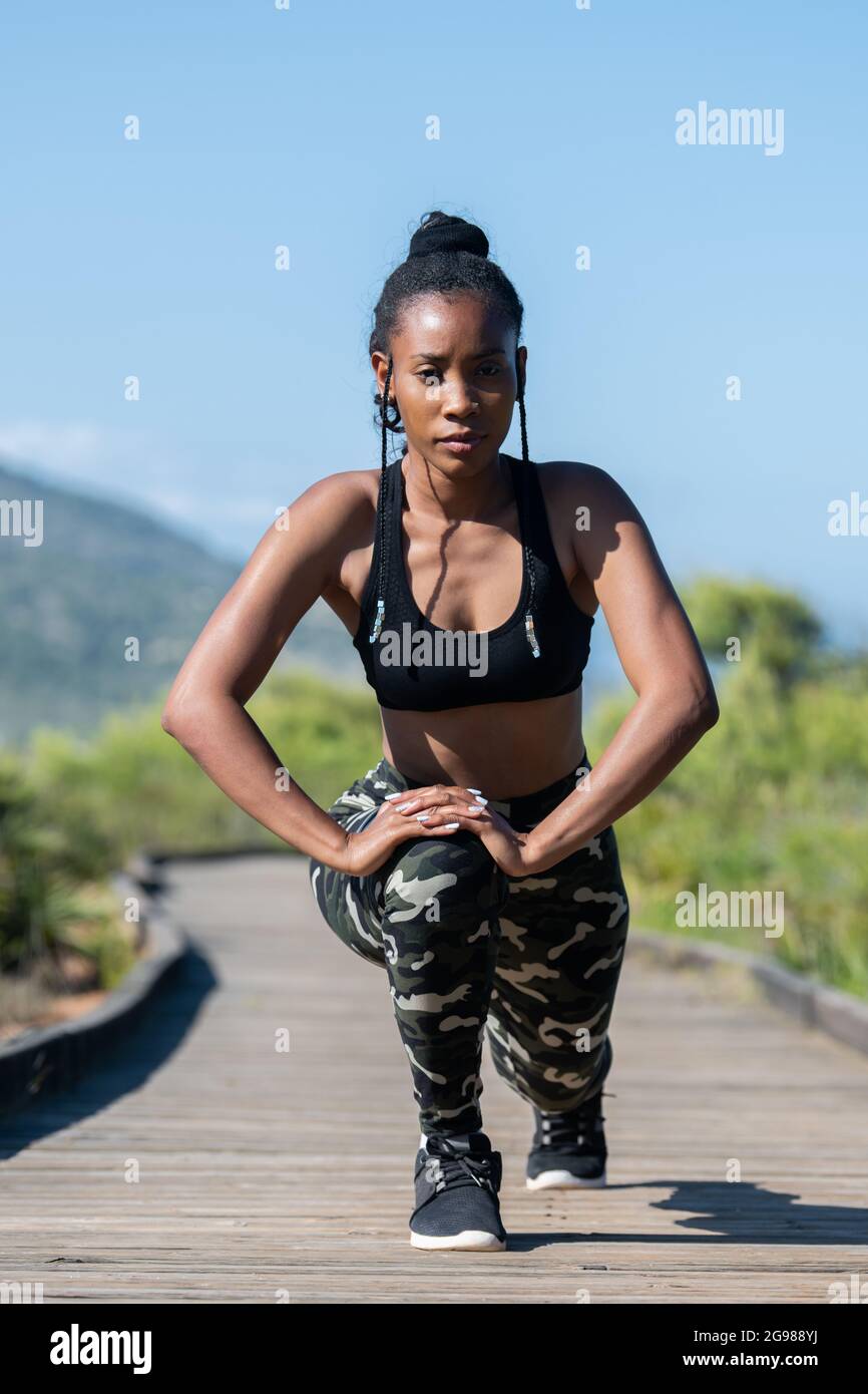 afro-american-woman-doing-stretches-on-a-wooden-runway-exercise-and