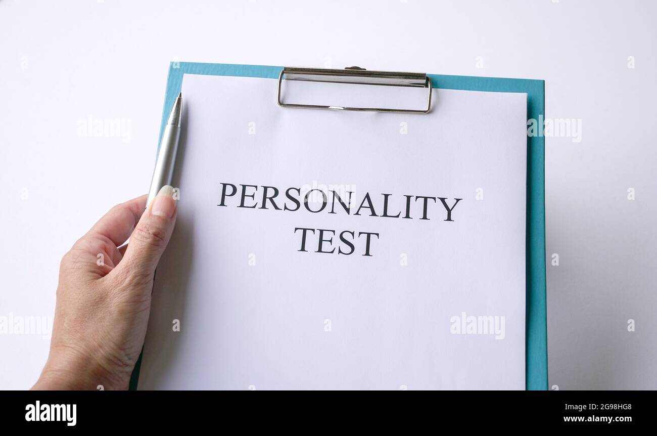 Woman holding a pen with personality test on clipboard. On white background. Stock Photo