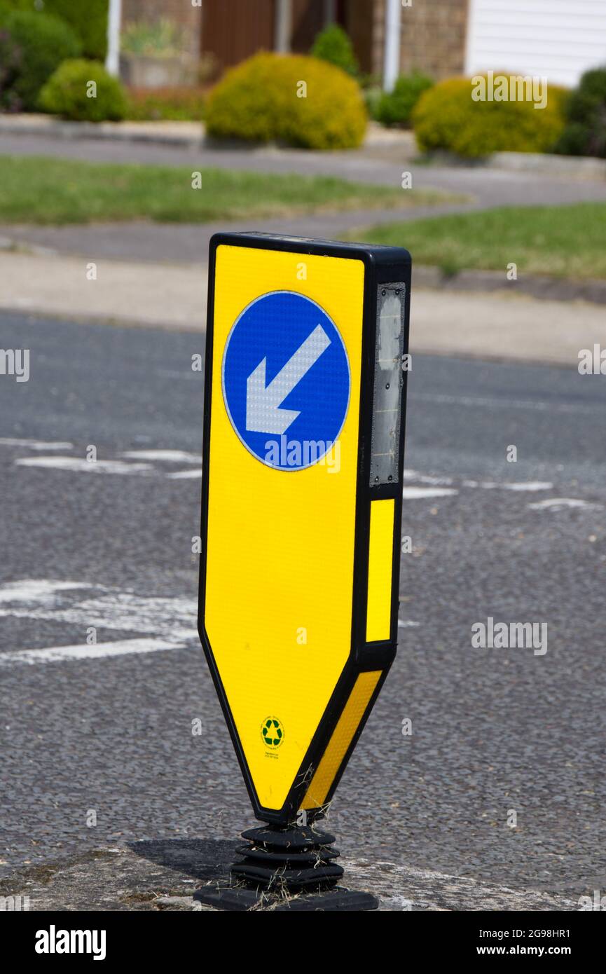 yellow reboundable illuminated bollard with keep left signage, at T junction UK Stock Photo