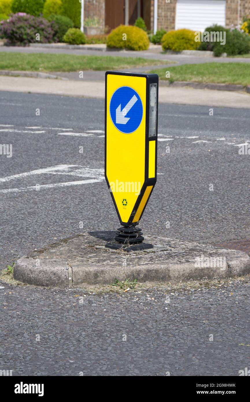 yellow reboundable illuminated bollard with keep left signage, at T junction UK Stock Photo