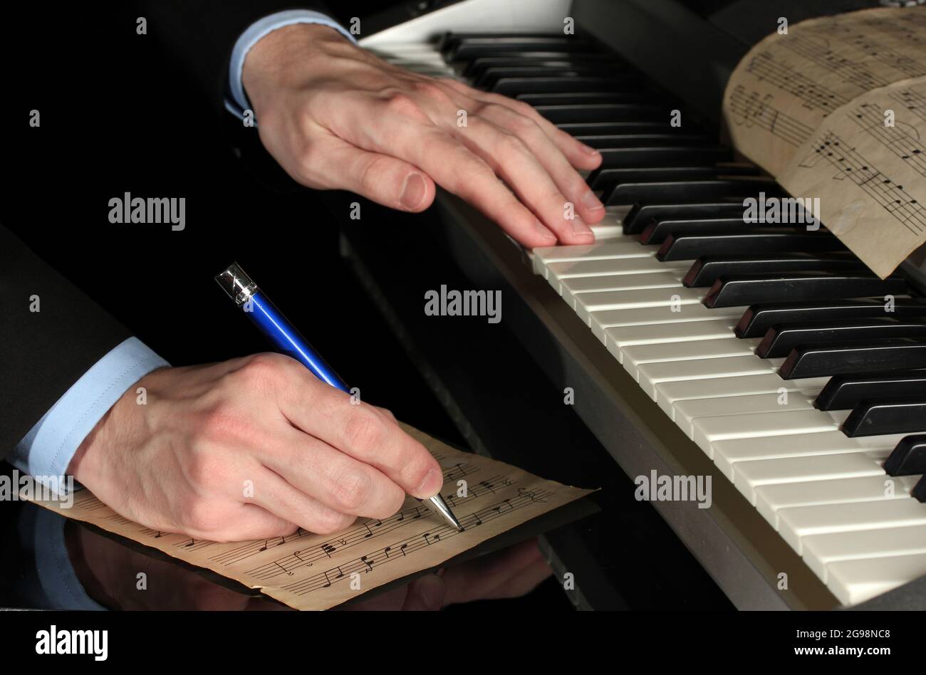 Man Hands Playing Piano And Writes On Parer For Notes Stock Photo Alamy