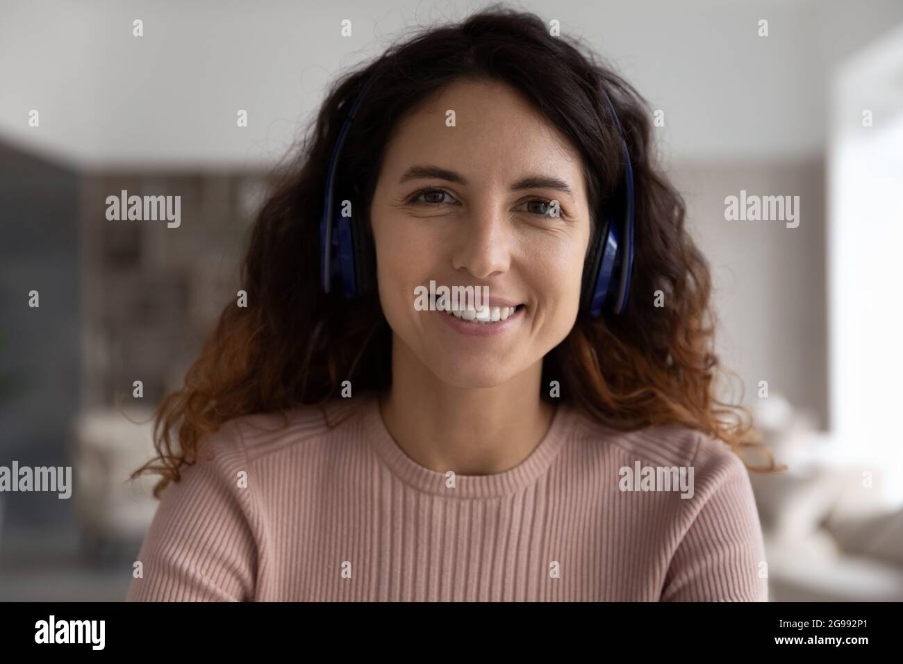 Headshot portrait of smiling Latin woman in headphones Stock Photo - Alamy