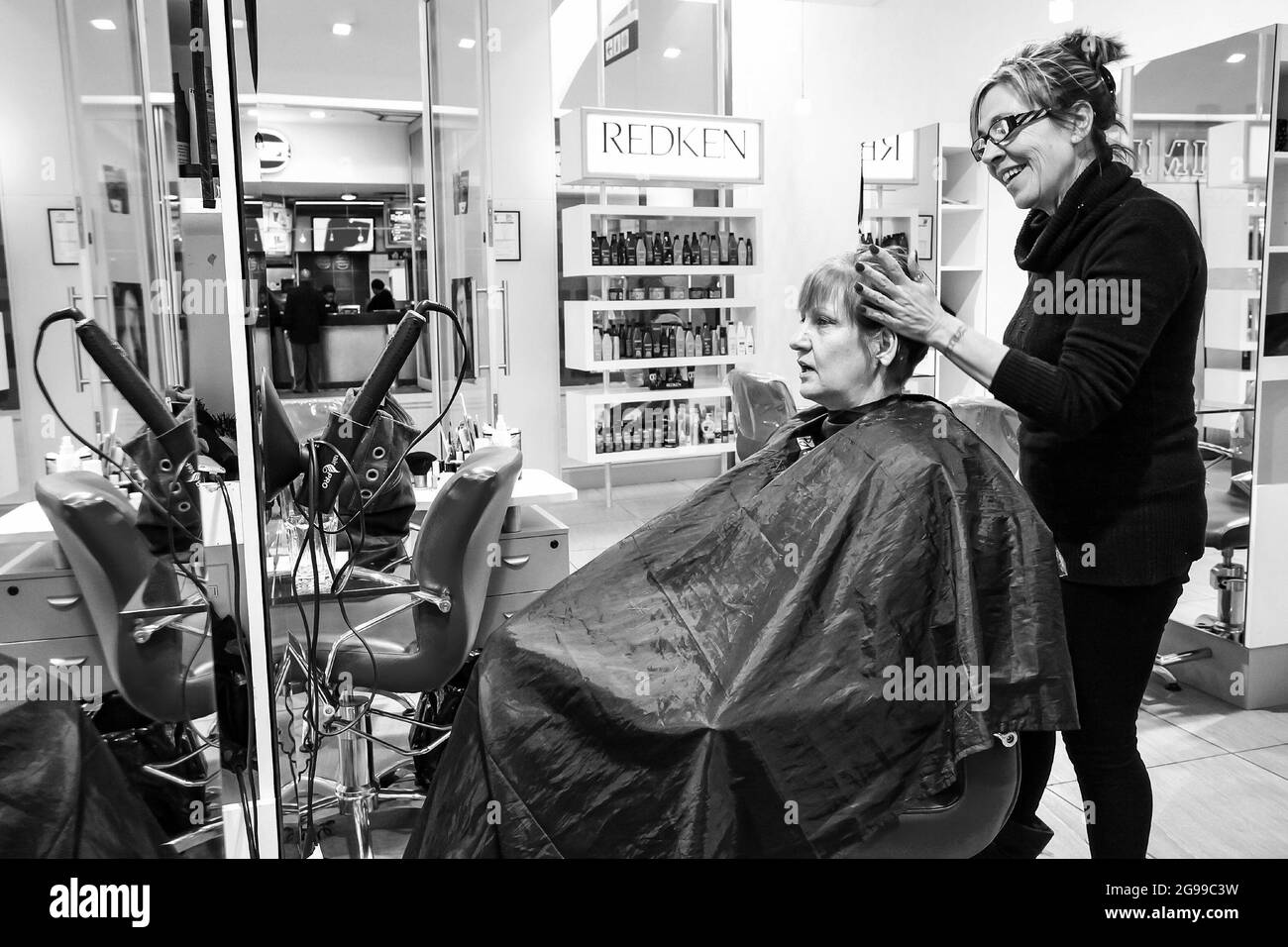 JOHANNESBURG, SOUTH AFRICA - Jan 06, 2021: A hairdresser styling a senior woman's hair Stock Photo
