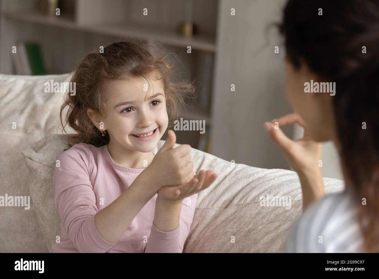 Smiling girl child talk using sign language Stock Photo