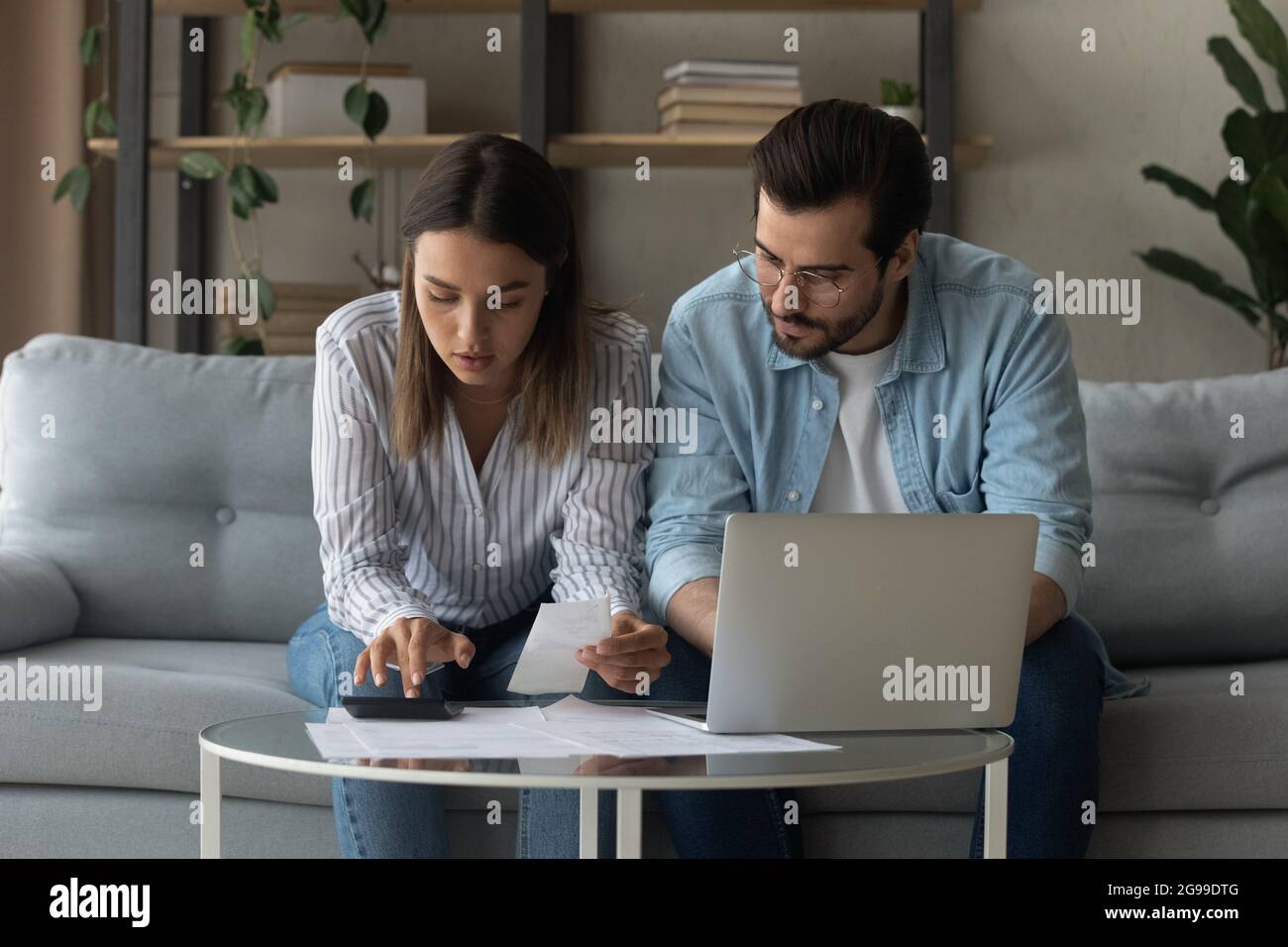 Serious millennial spouses calculate expenses sit on sofa at home Stock  Photo - Alamy