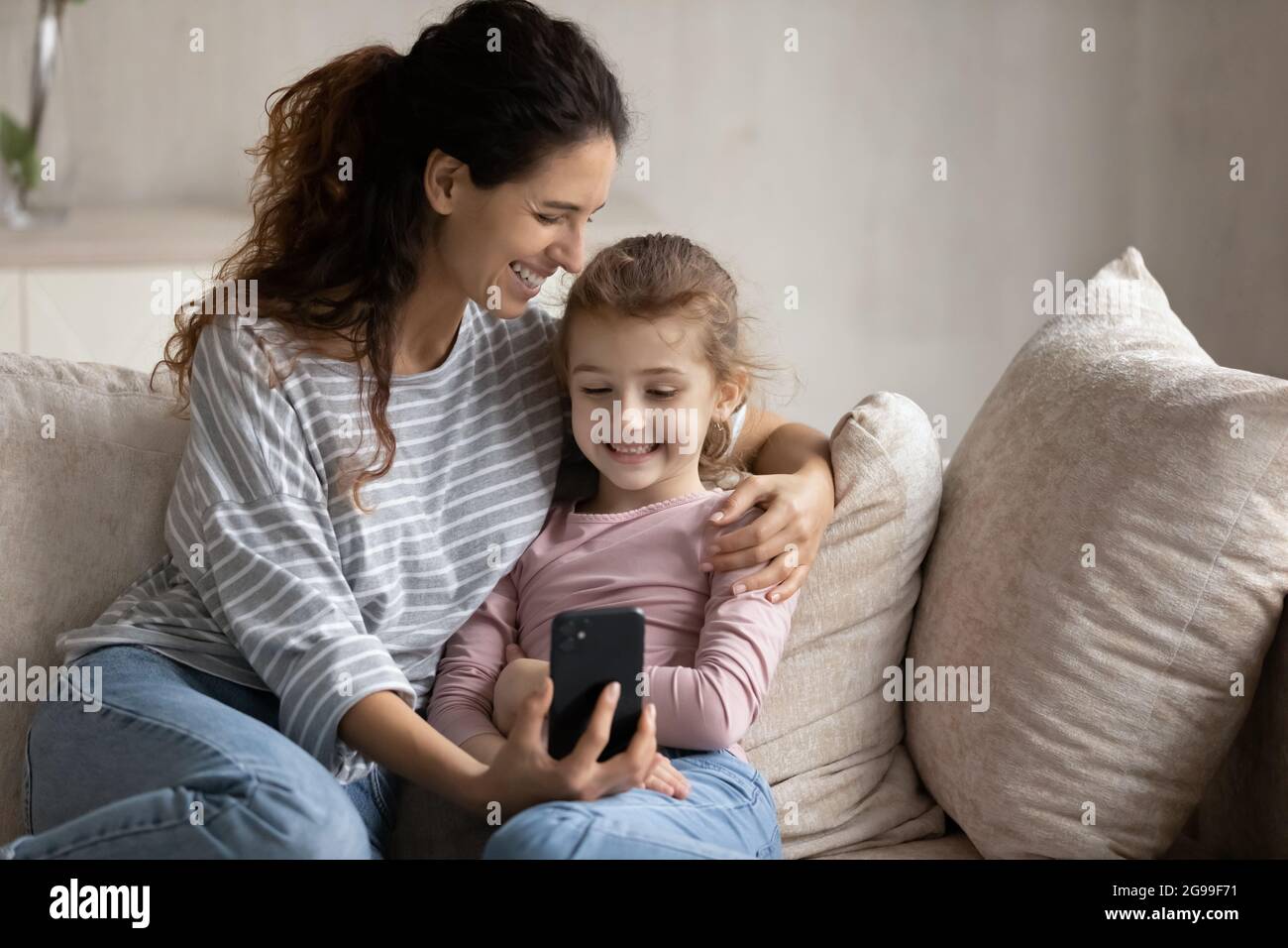 Smiling Latino mother and daughter have webcam call on smartphone Stock ...