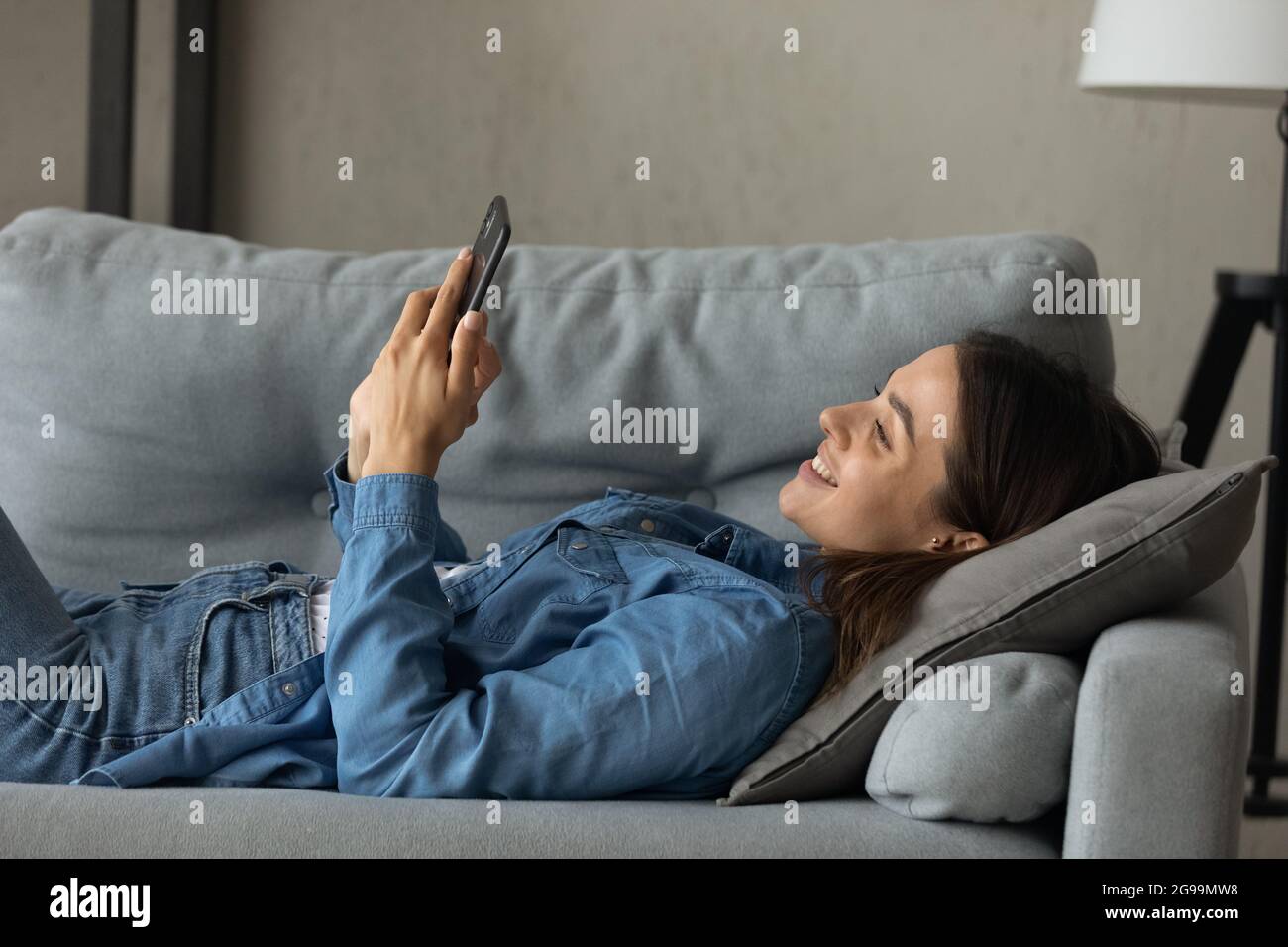 Woman relax indoor use cellphone spend free time on internet Stock Photo