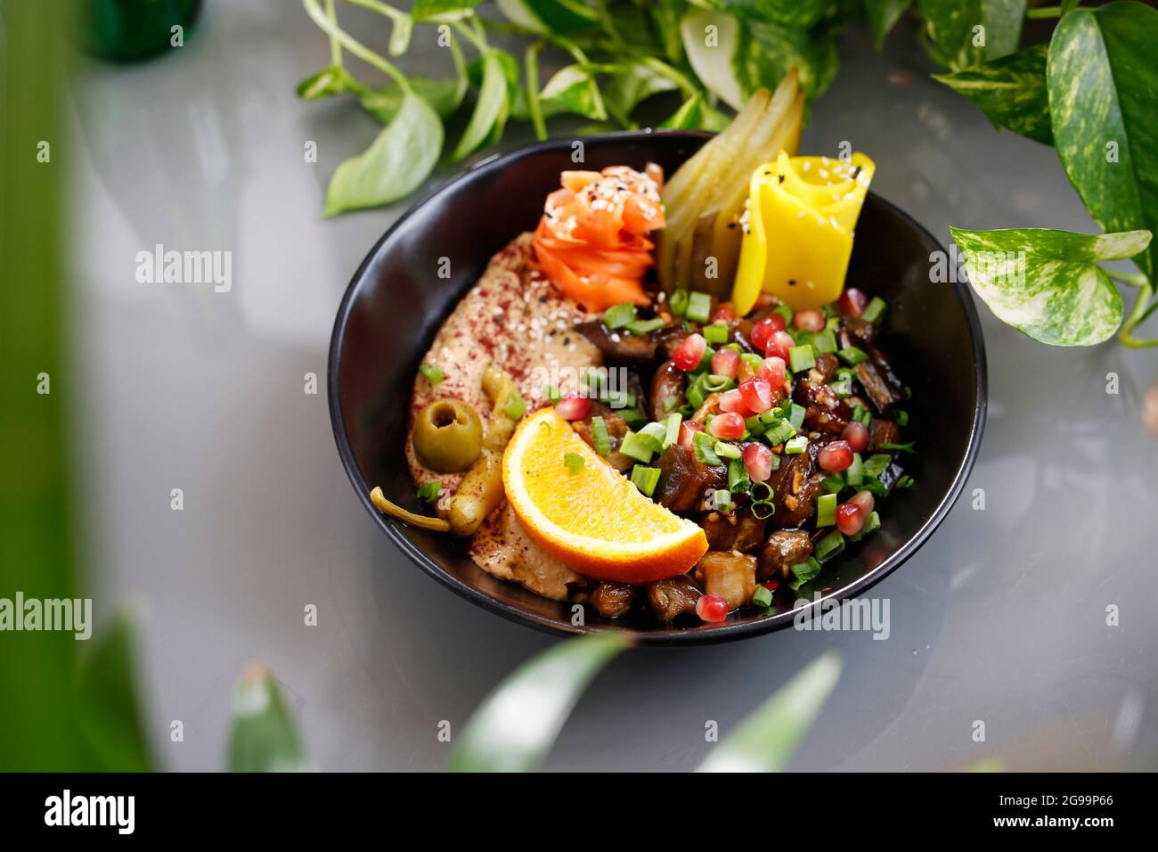 Humus with a patch of mushrooms and vegetables. Vegetarian dish, food photography, serving proposal. Stock Photo