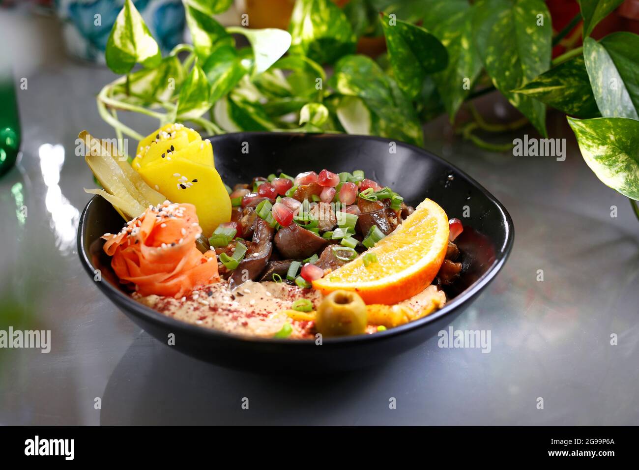 Humus with a patch of mushrooms and vegetables. Vegetarian dish, food photography, serving proposal. Stock Photo