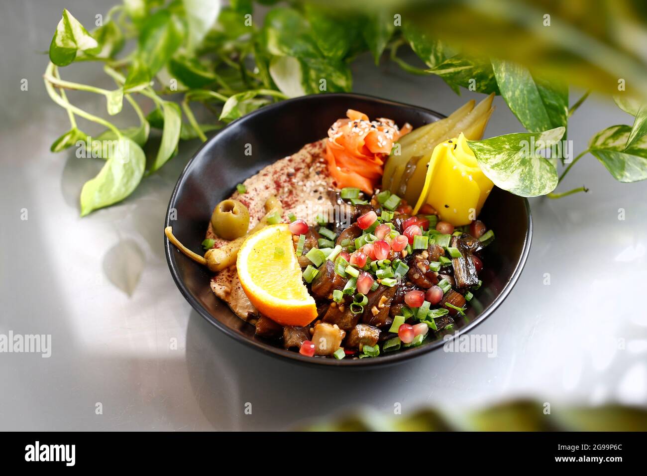 Humus with a patch of mushrooms and vegetables. Vegetarian dish, food photography, serving proposal. Stock Photo