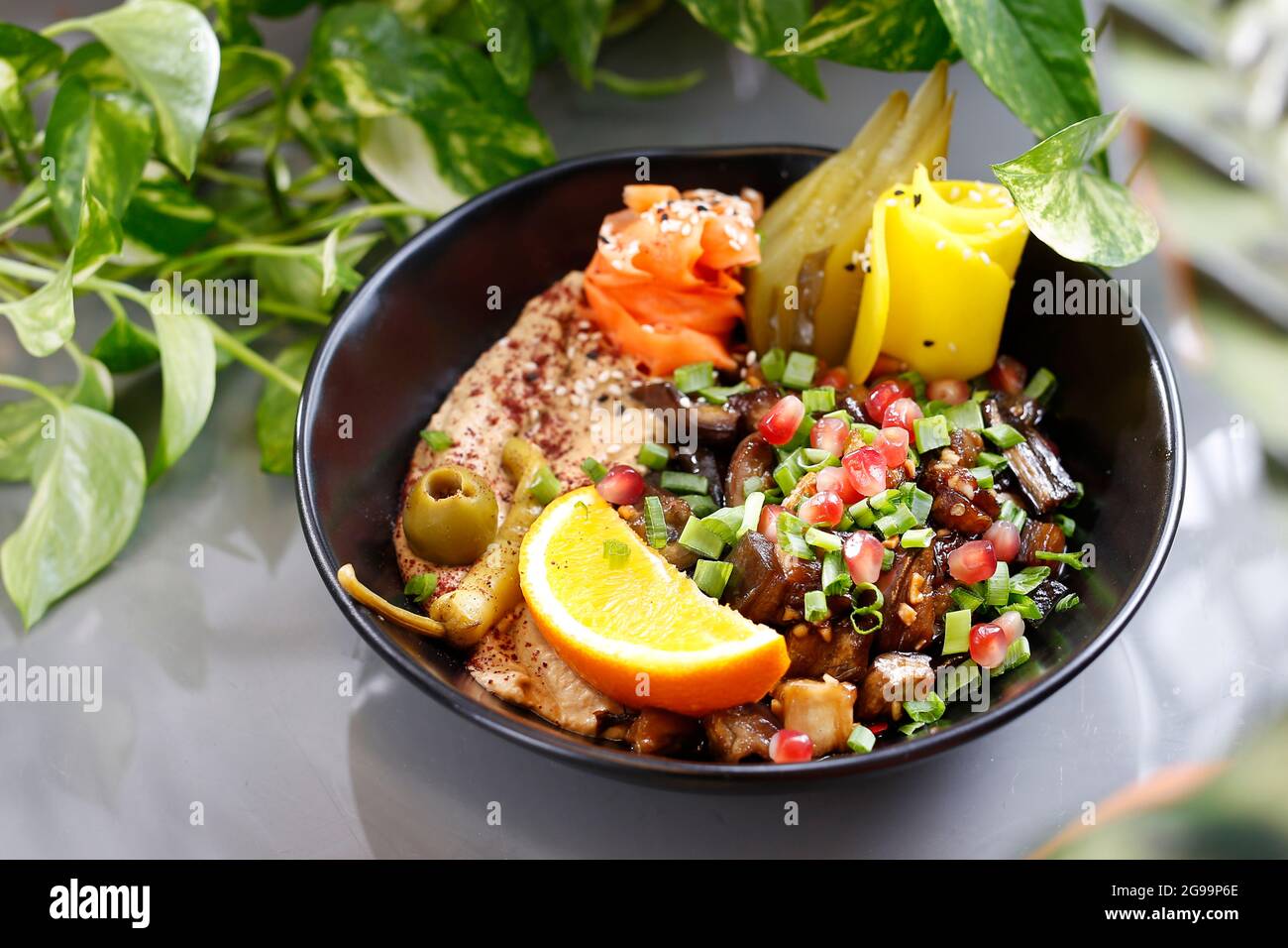 Humus with a patch of mushrooms and vegetables. Vegetarian dish, food photography, serving proposal. Stock Photo