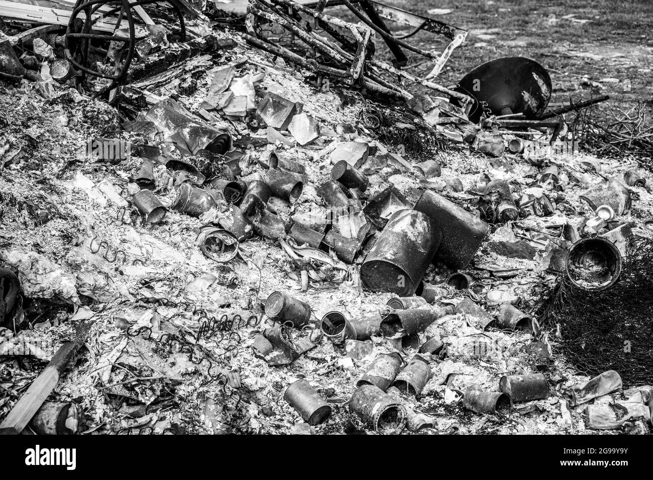 Burning rubbish on a bonfire containing metal tin cans Stock Photo