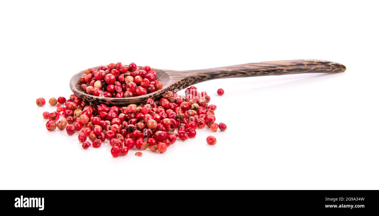 dried pink peppers in wood spoon isolated on white background Stock Photo