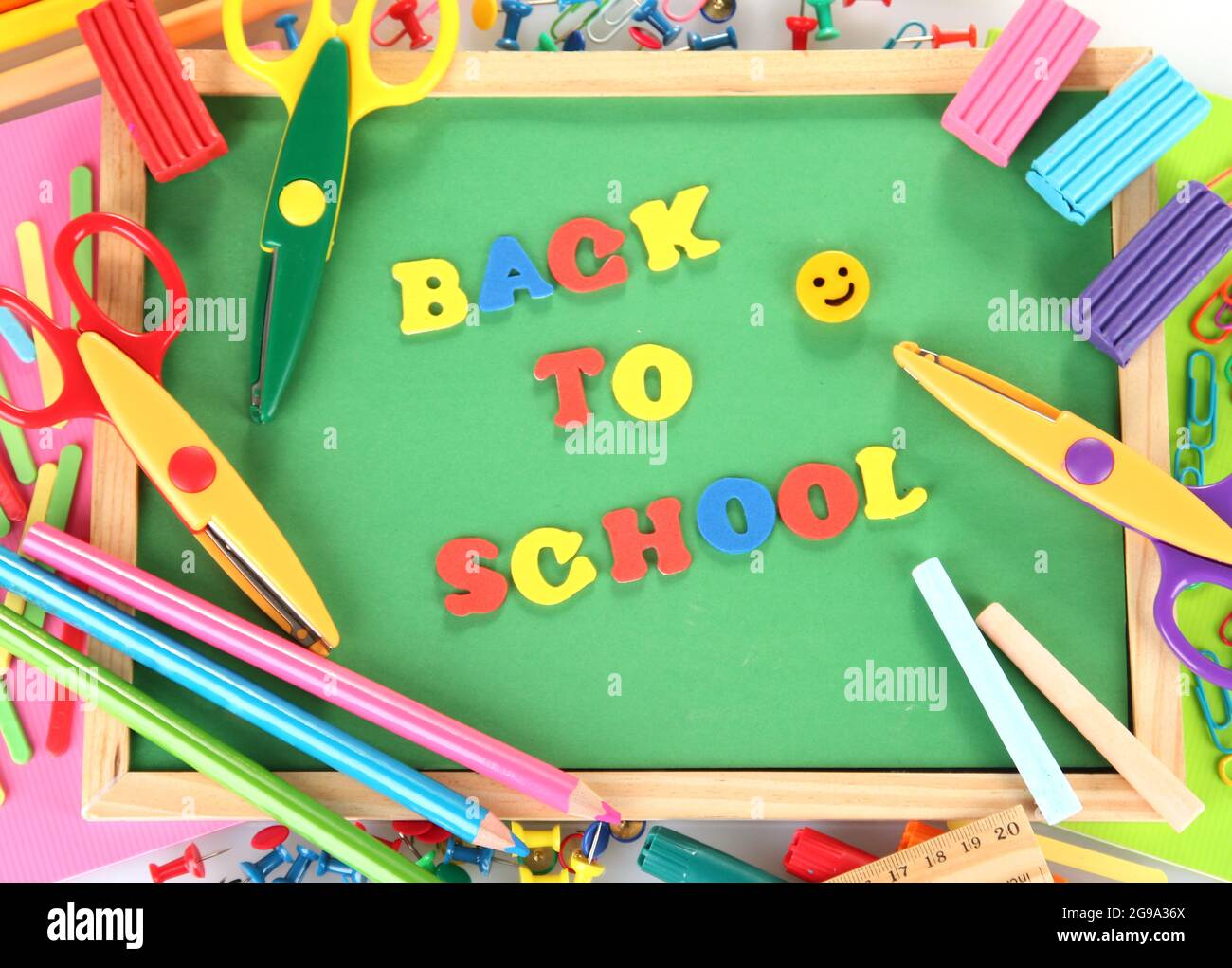 Small chalkboard with school supplies on white background. Back to ...