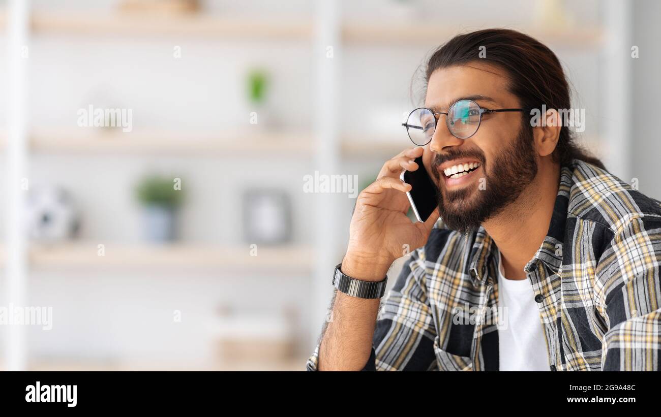 Smiling arab guy talking on cellphone, closeup portrait Stock Photo