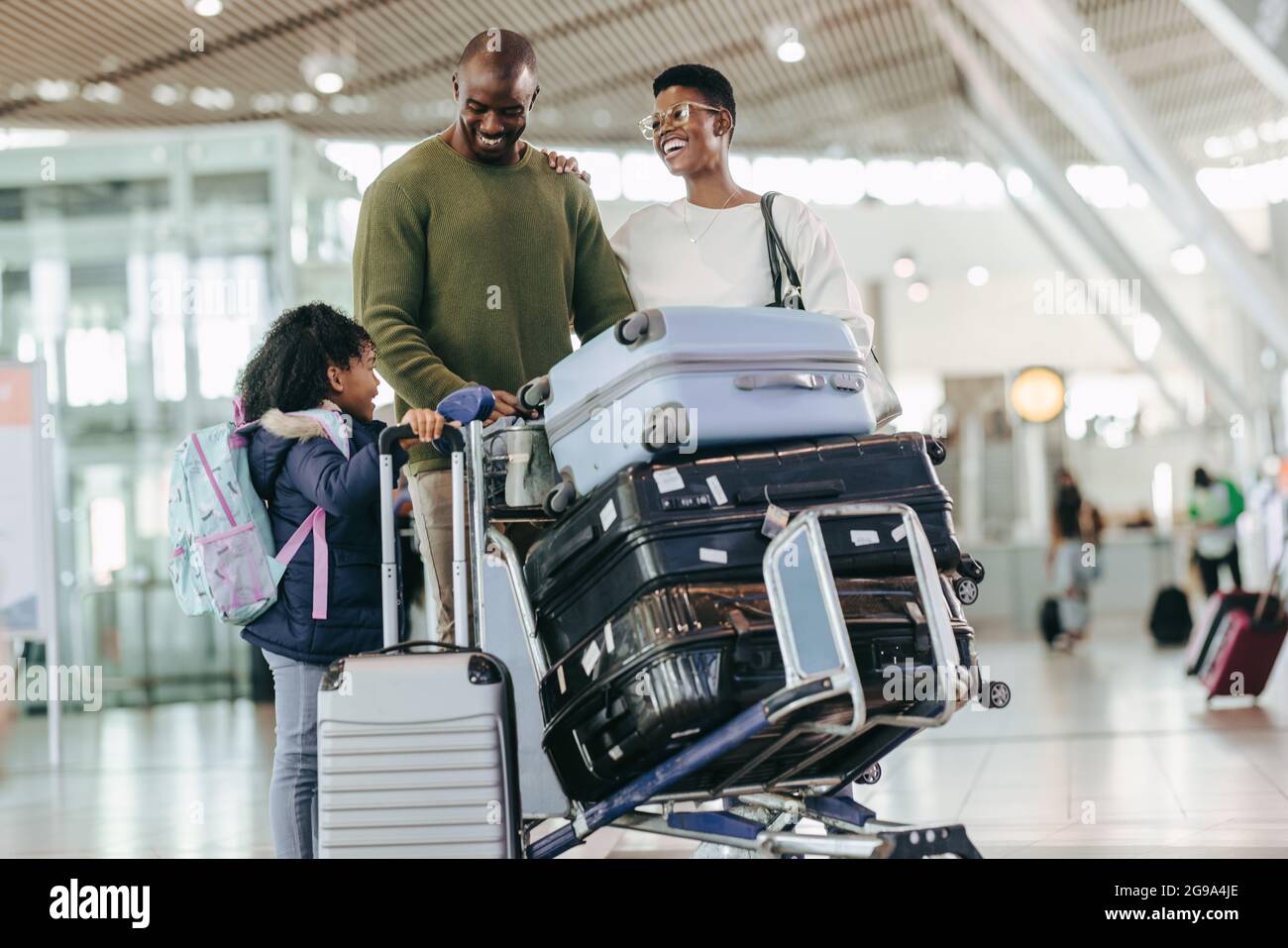 Family standing at airport terminal while waiting for flight. Parents