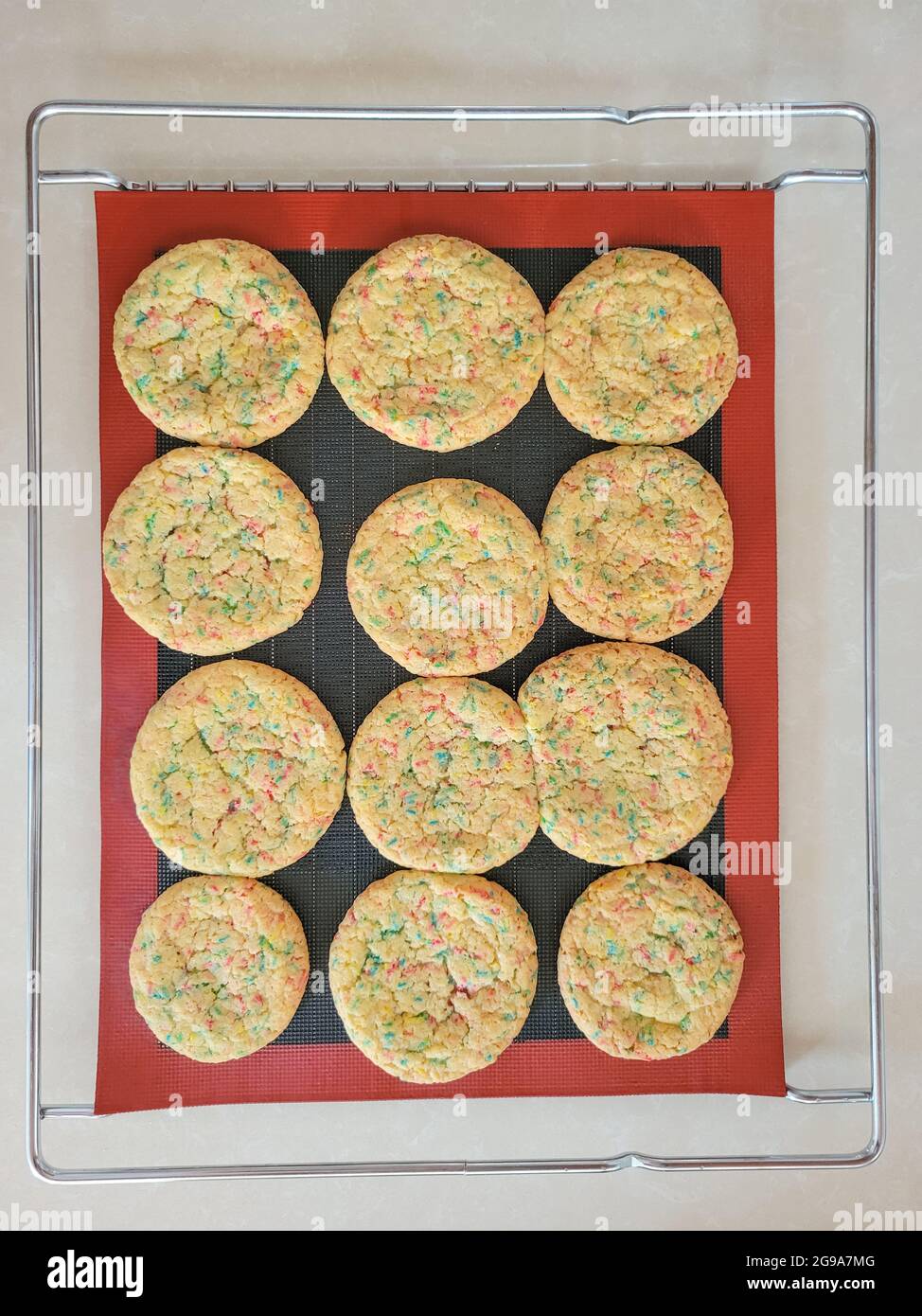Fluffy sprinkle cookies on silicone mat on wire metal baking rack Stock