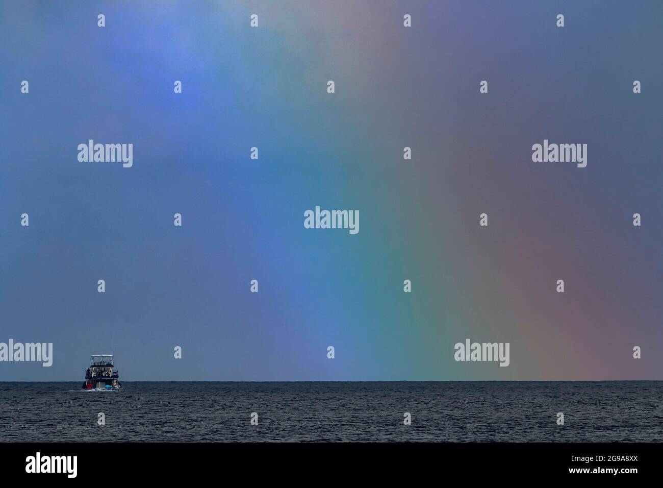 Fishing boat under rainbow in Indian Ocean Stock Photo