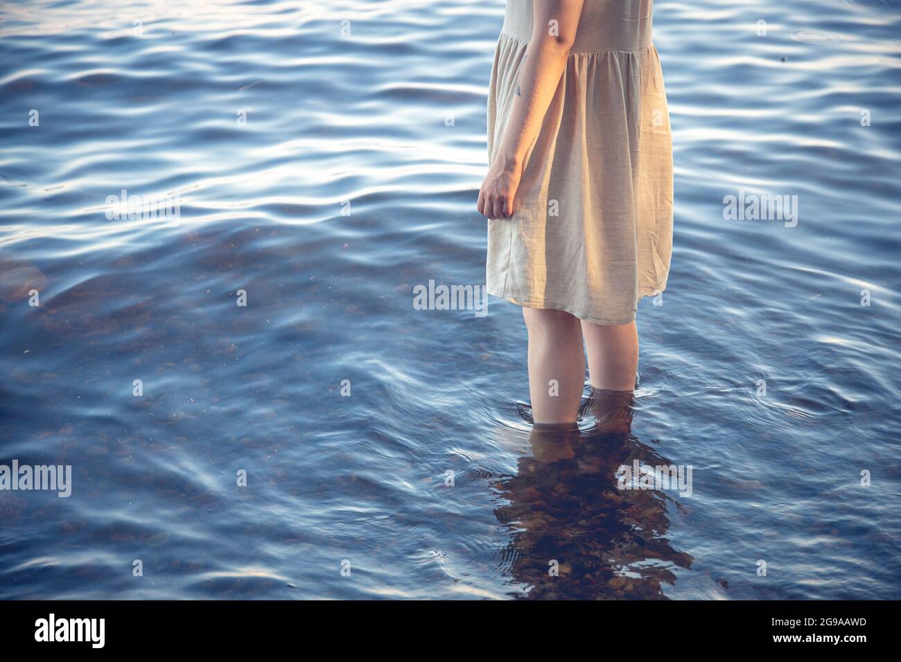 A young female in a dress standing in water Stock Photo - Alamy