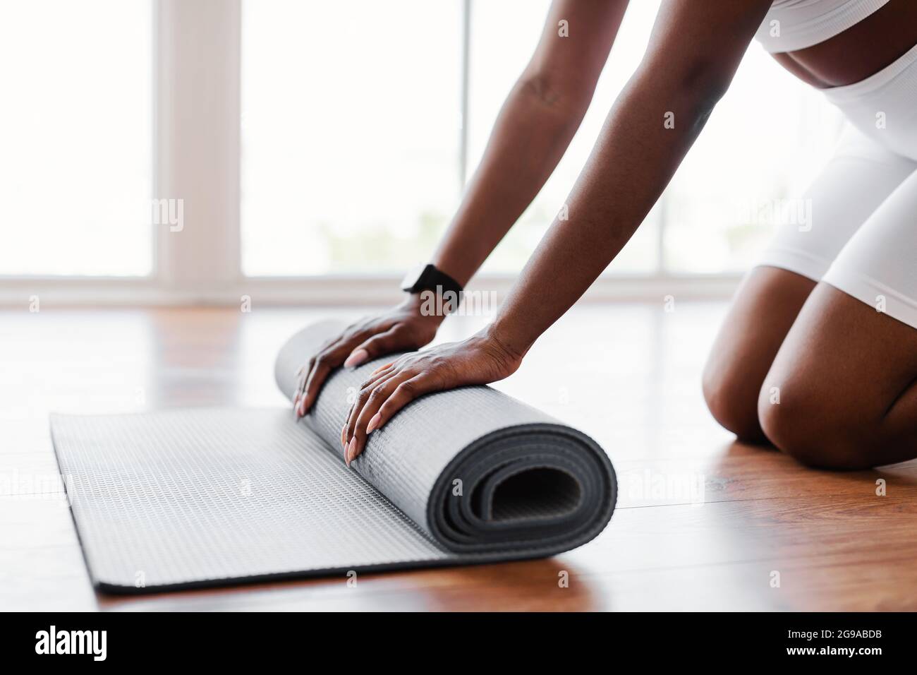 Young black woman unrolling yoga mat on floor Stock Photo Alamy