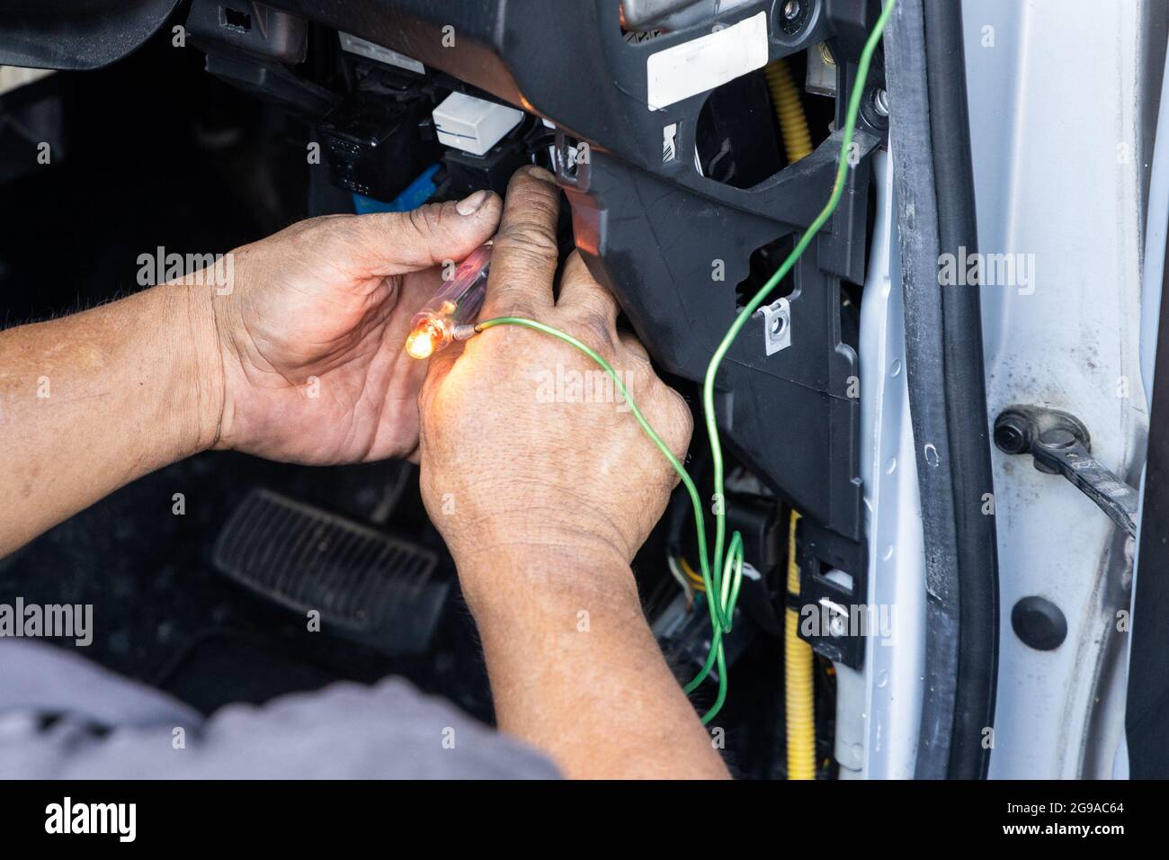 Auto technician diagnose car fixing wiring problem with test pen Stock Photo