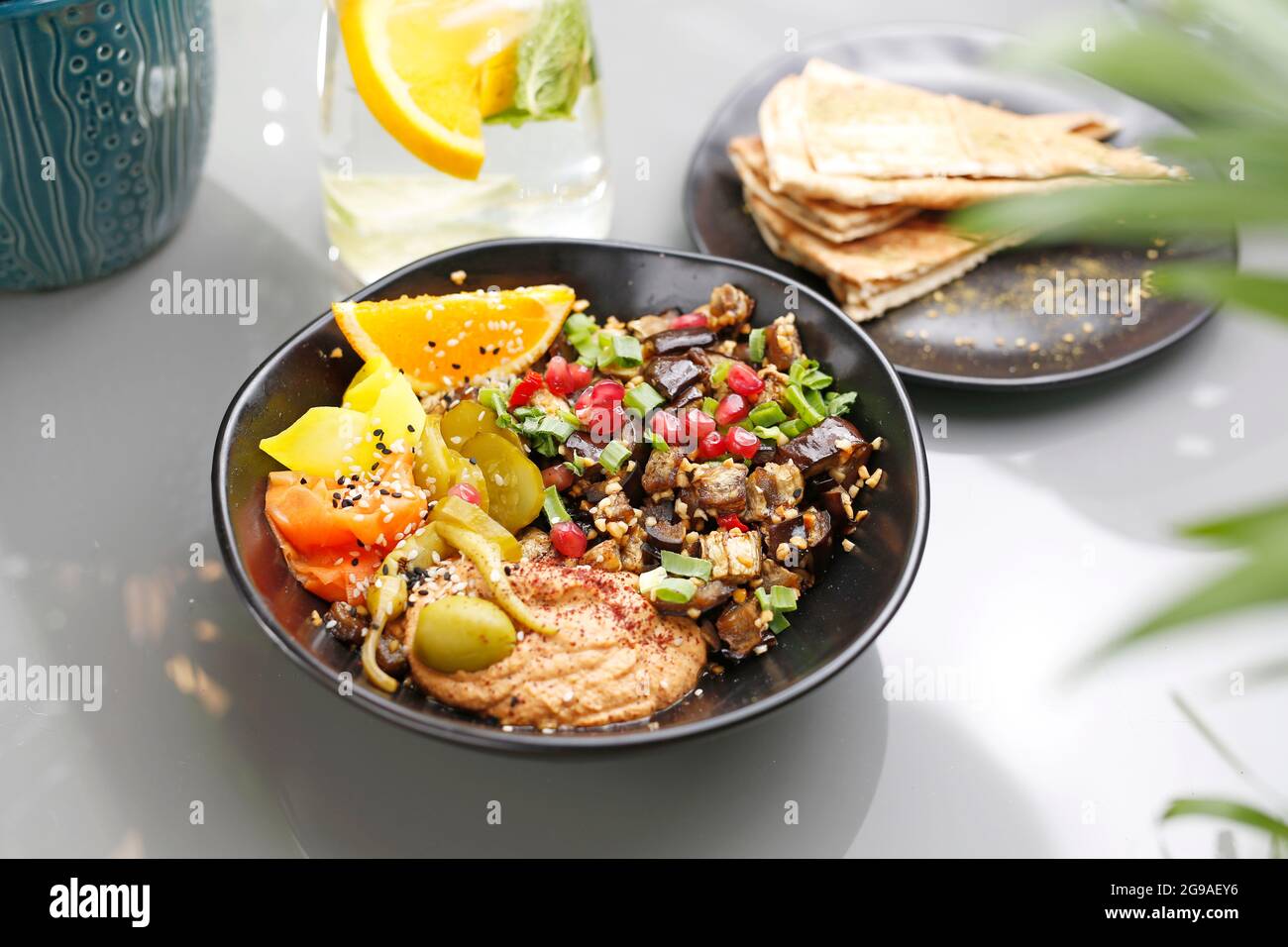 Humus with eggplant and olive salad. Vegetarian cooking. A colorful appetizing dish. Culinary photography, food styling. Stock Photo