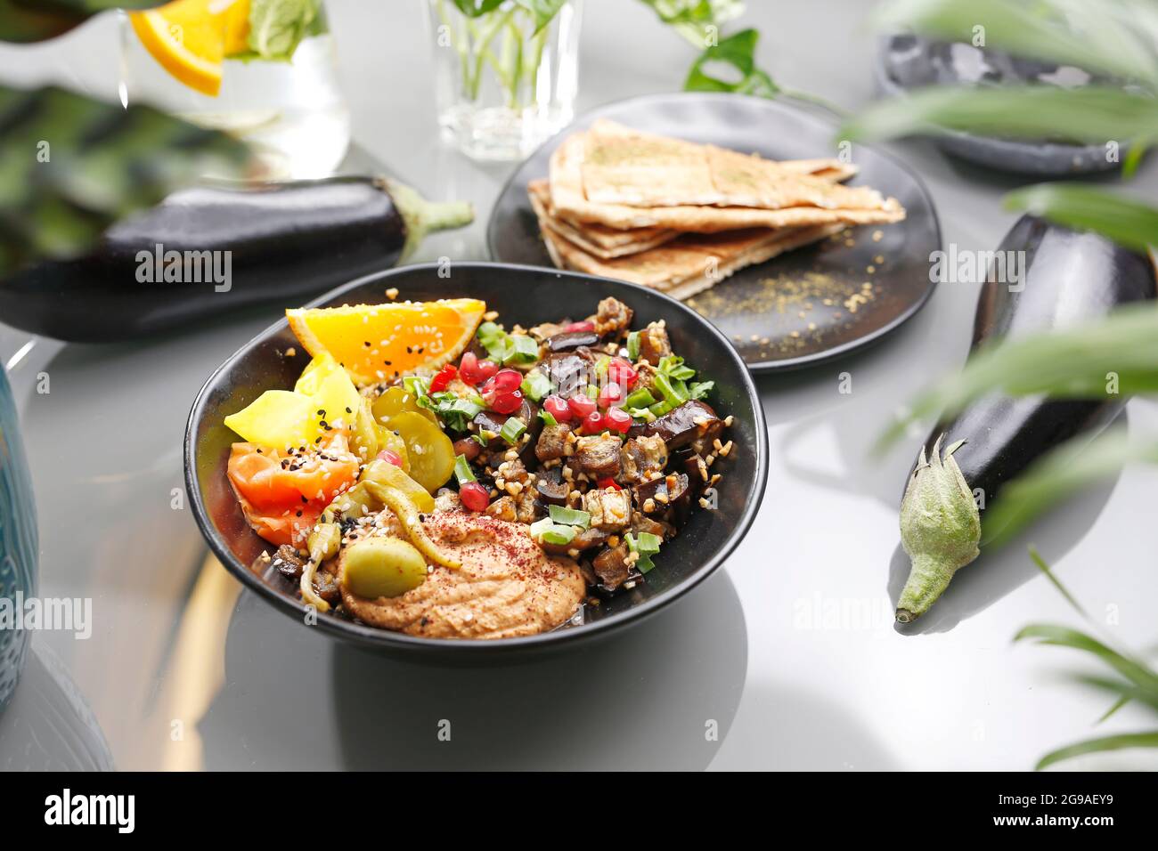 Humus with eggplant and olive salad. Vegetarian cooking. A colorful appetizing dish. Culinary photography, food styling. Stock Photo