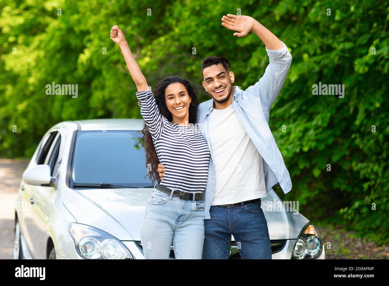 Emotional multiracial couple standing by nice auto Stock Photo