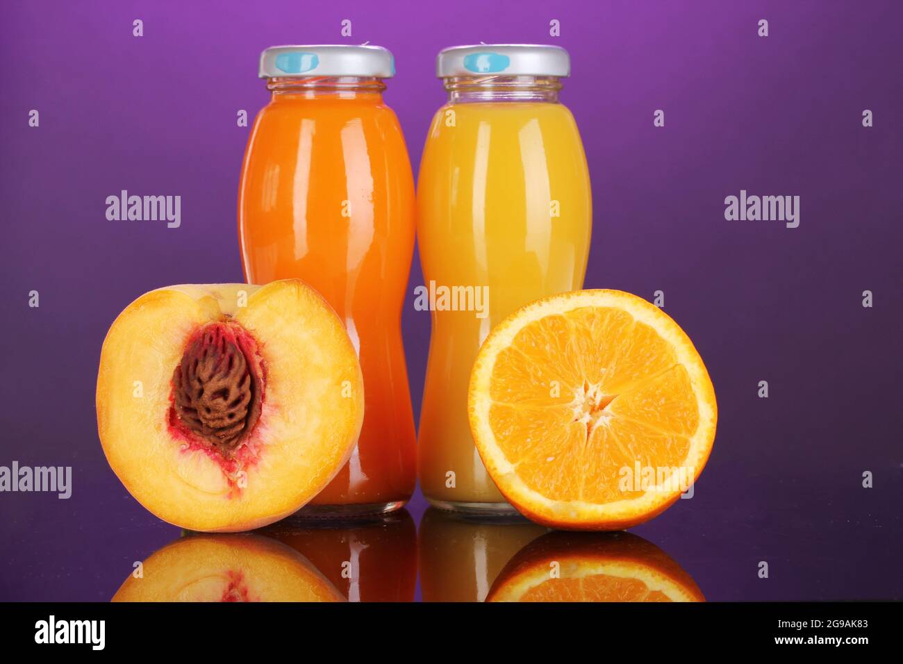 Delicious orange and peach juice in bottle and orange and peach next to