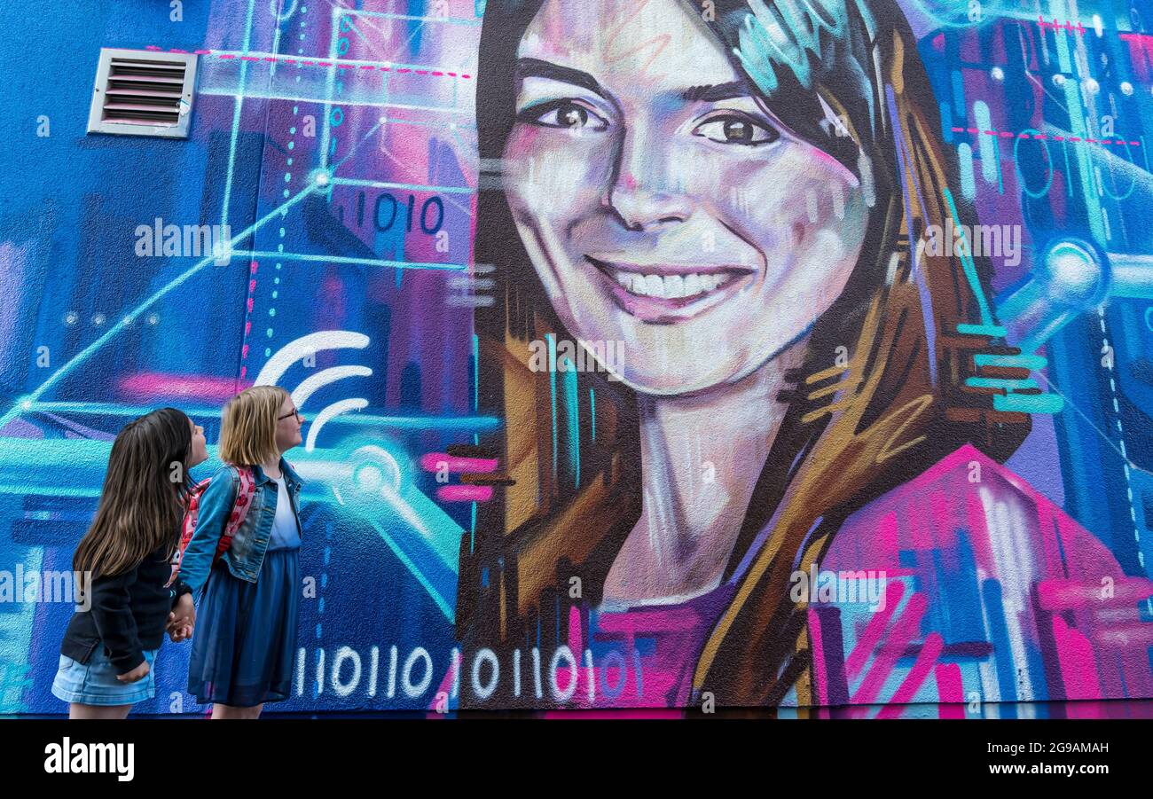 Girls walk by a mural by graffiti artist Shona Hardie for Edinburgh Science festival of CEO Natalie Duffield celebrates women in STEM, Scotland, UK Stock Photo