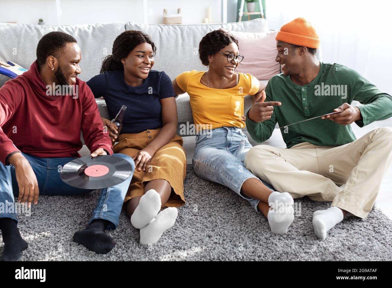 Charismatic black guy showing his friends vynil records Stock Photo