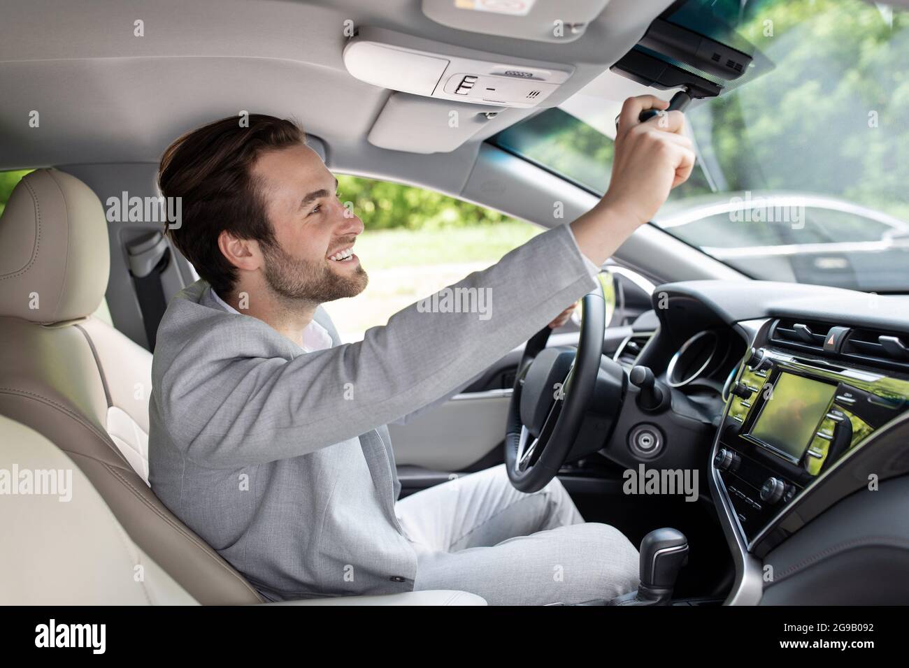 https://c8.alamy.com/comp/2G9B092/man-sitting-in-car-and-adjusting-rearview-mirror-car-interior-road-to-office-2G9B092.jpg