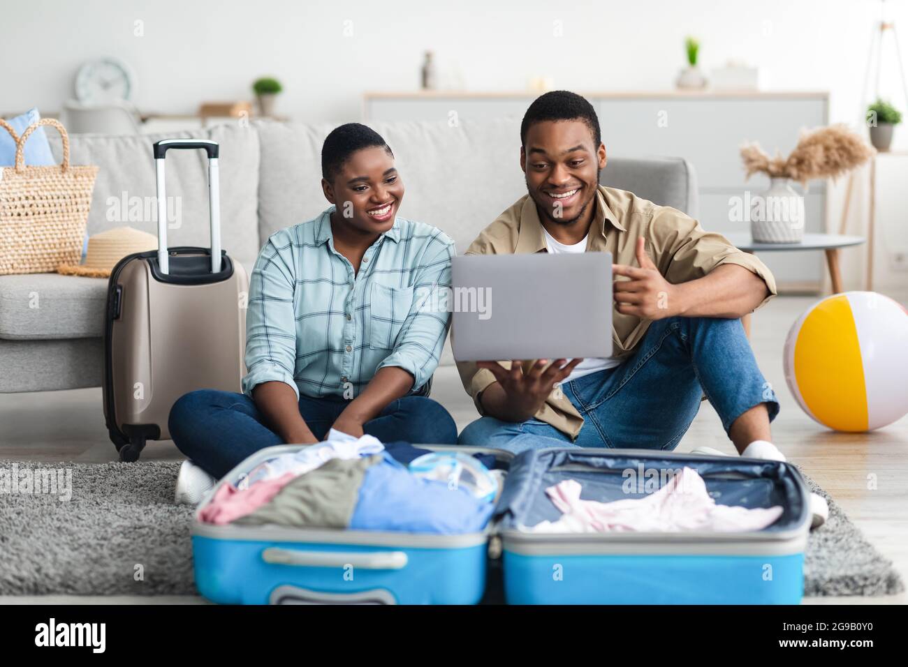 African American Family Couple Using Laptop Planning Vacation At Home Stock Photo