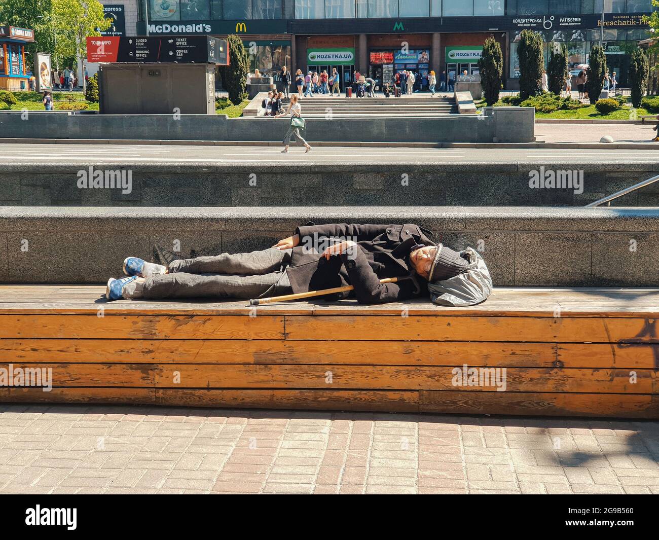 Kiev, Ukraine-April 30, 2018: Homeless man sleeping on the bench on Kreschatik street in Kiev, Ukraine.  Ukraine has one of the highest rates of homel Stock Photo