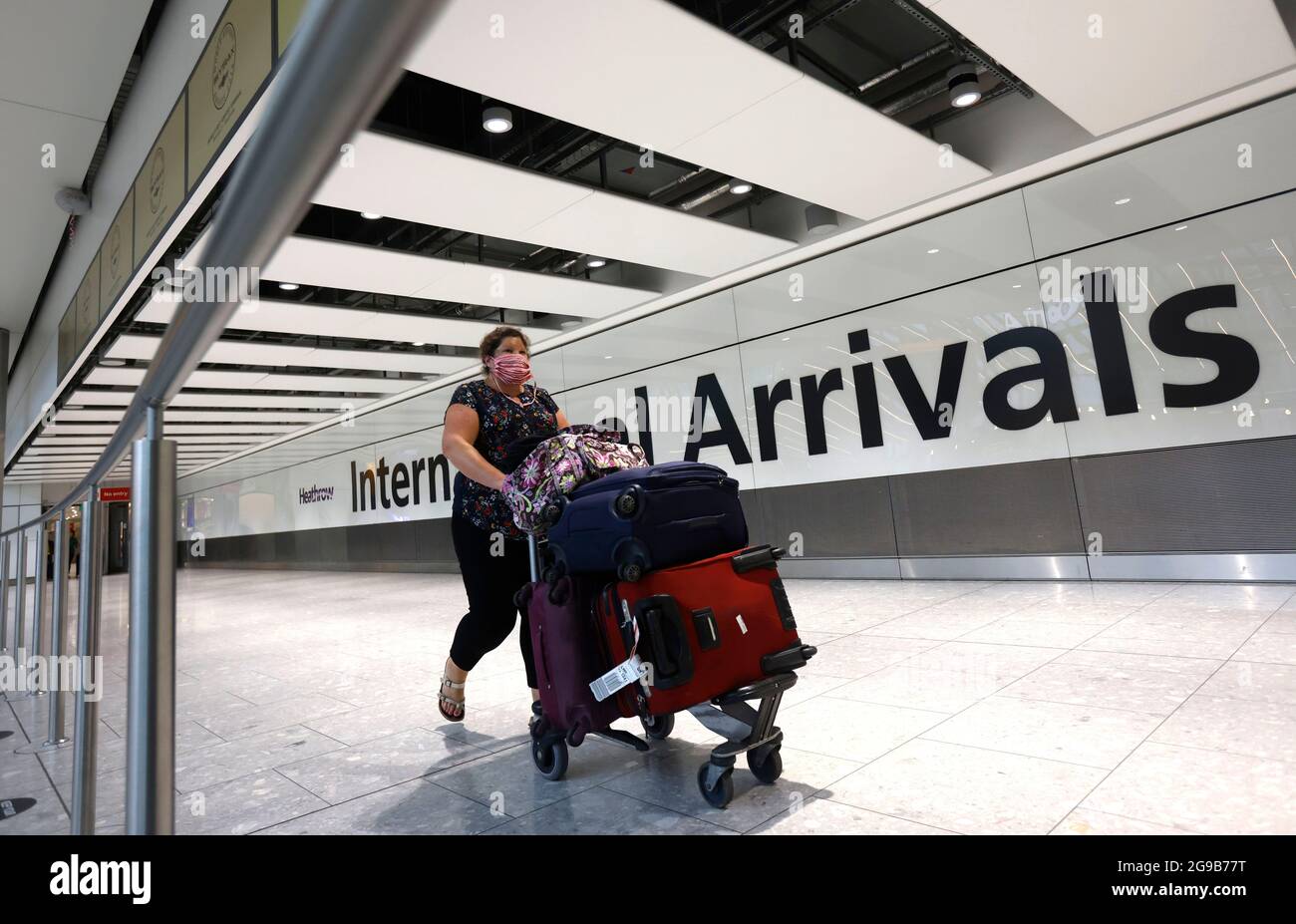 London, UK. 25th July, 2021. A passenger arrives at Terminal 5. Passengers departing and arriving at Heathrow airport as the holiday season starts. The traffic light system is in place with different rules for Green, Amber and Red list countries. Some passengers will have to self isolate on arrival. Credit: Mark Thomas/Alamy Live News Stock Photo