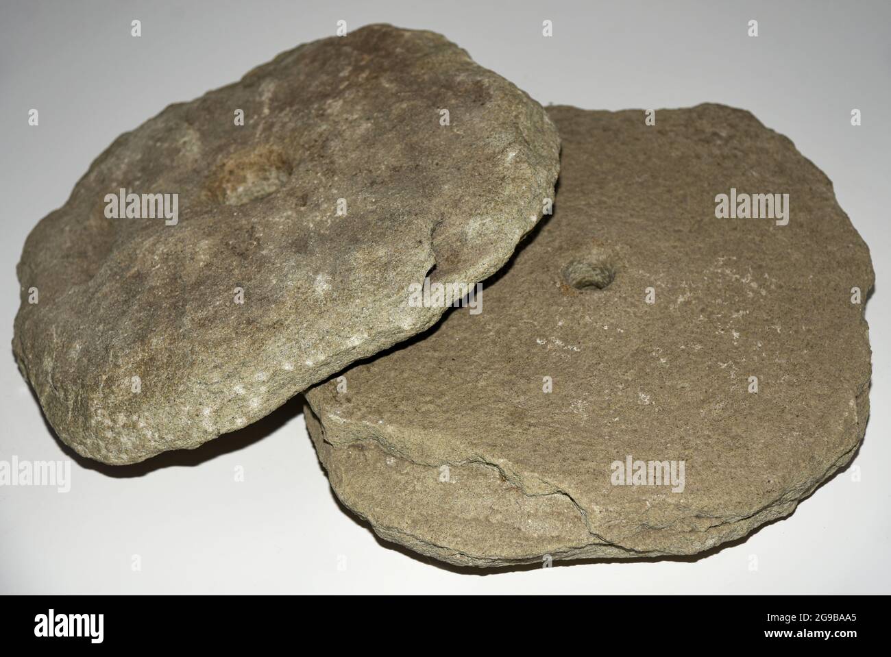 Ancient stone millstones for grinding grain, isolate. Stock Photo