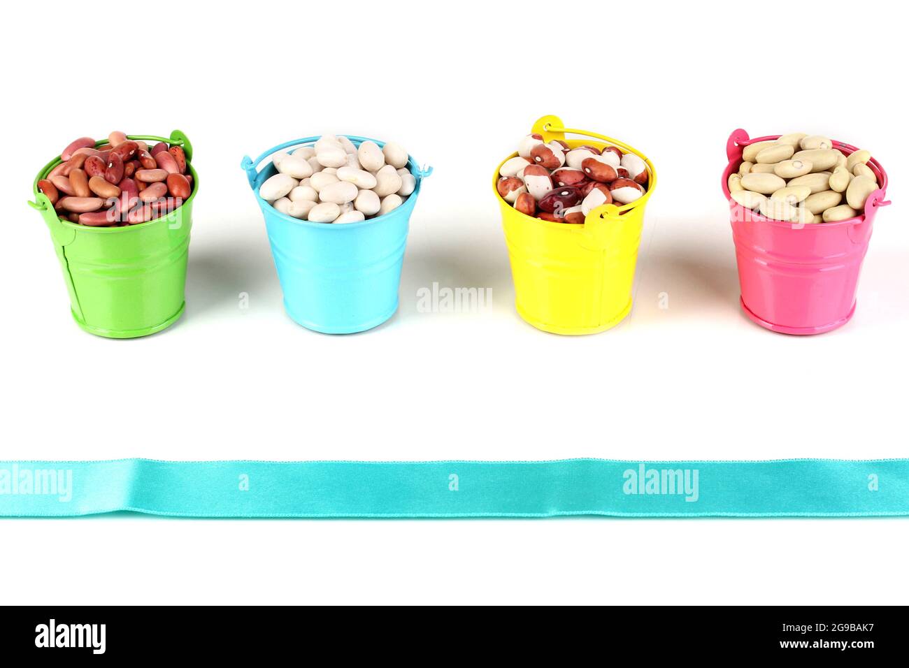 Different types of beans in colored buckets isolated on white Stock