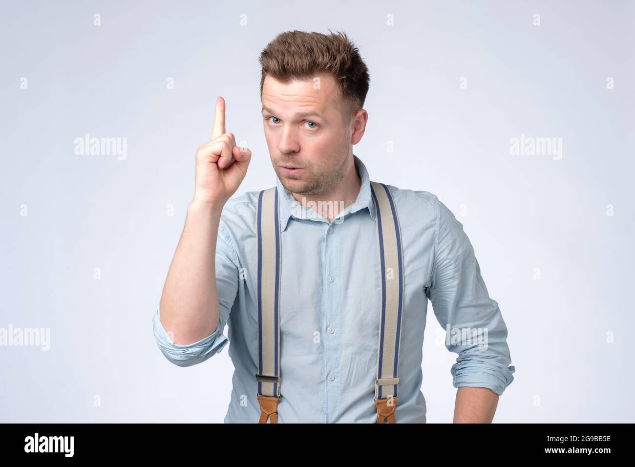 Satisfied young man showing index fingers up, giving advice or recommendation Stock Photo