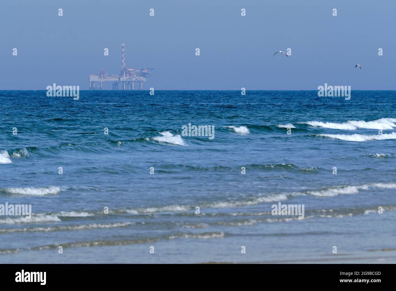 Ameland,Netherlands April 20,2021-NAM, Oil rig, offshore platform with beach, sand and surf. Natural gas extraction in the Wadden-North Sea Region Stock Photo
