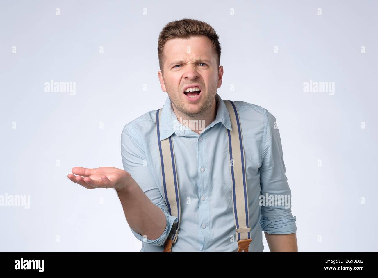 man with angry facial expression asking so what do you want from me. Stock Photo