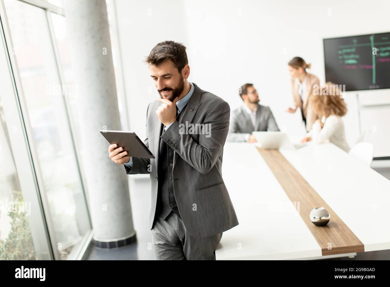 Handsome young modern businessman using digital tablet in the office ...