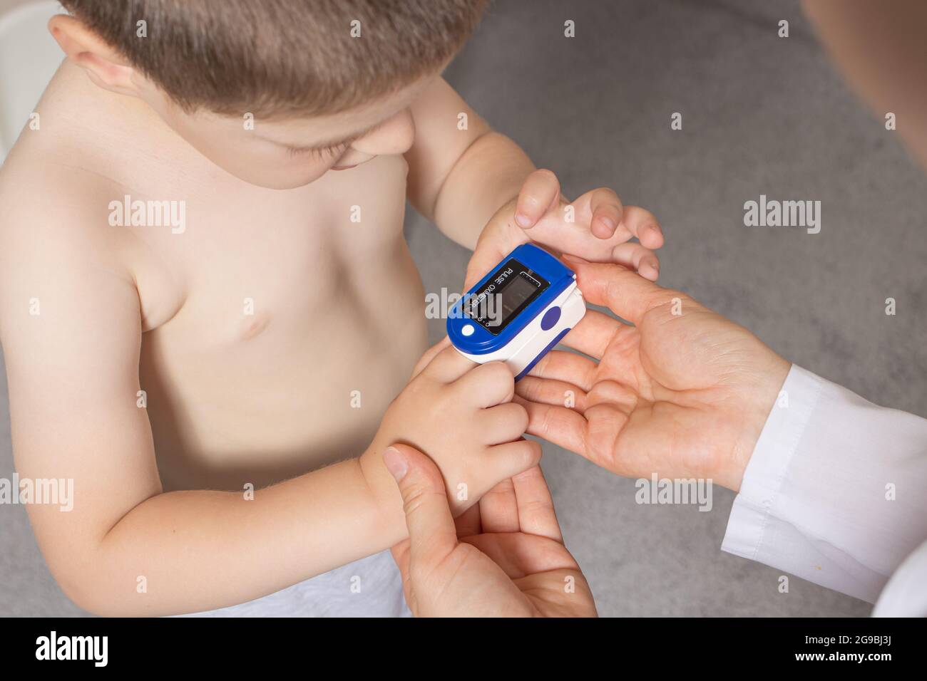 The pediatrician measures the child's blood oxygen level with a pulse ...