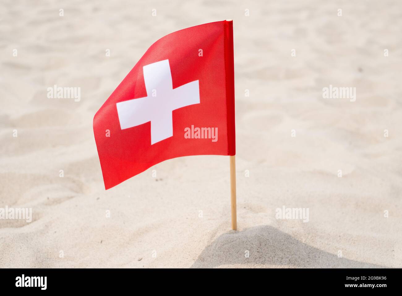 Flag of Switzerland on sand background. Swiss flag waving in wind on summer  beach Stock Photo - Alamy