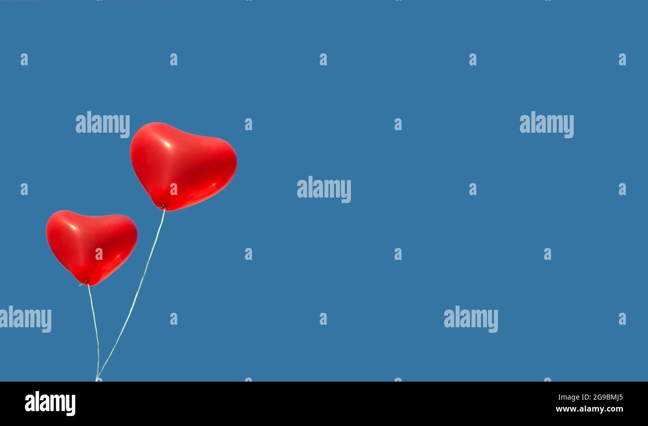Two red balloon in the blue sky. Symbol of love and tenderness ...