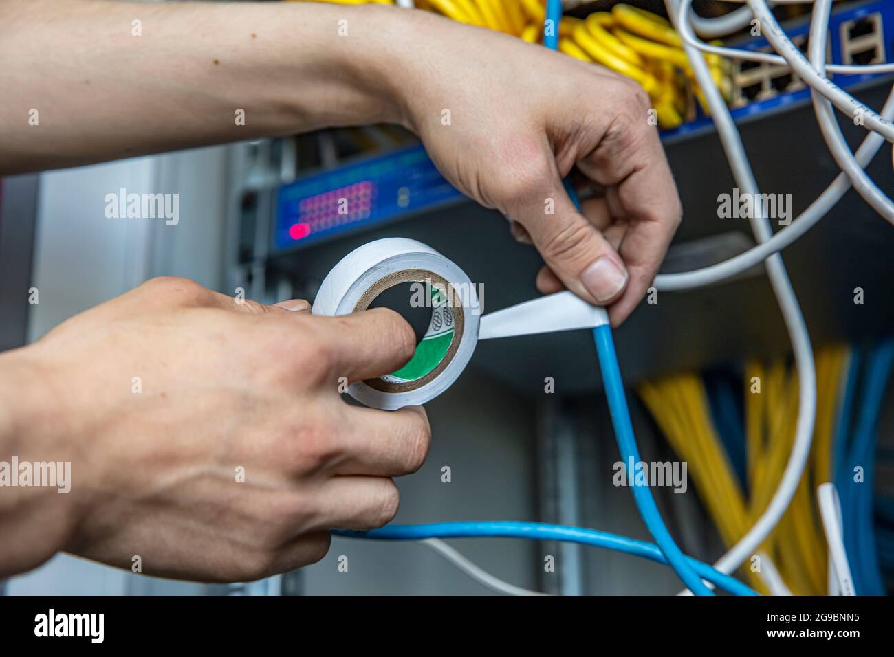 Electrician is repairing the wiring in the electrical room with