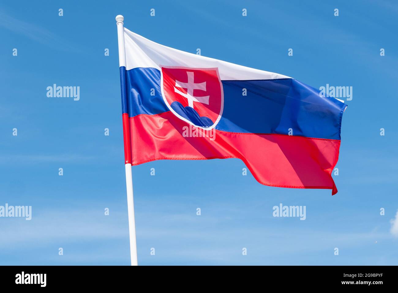 Flag of Slovakia on blue sky background. Slovak flag waving in wind and sunlight Stock Photo