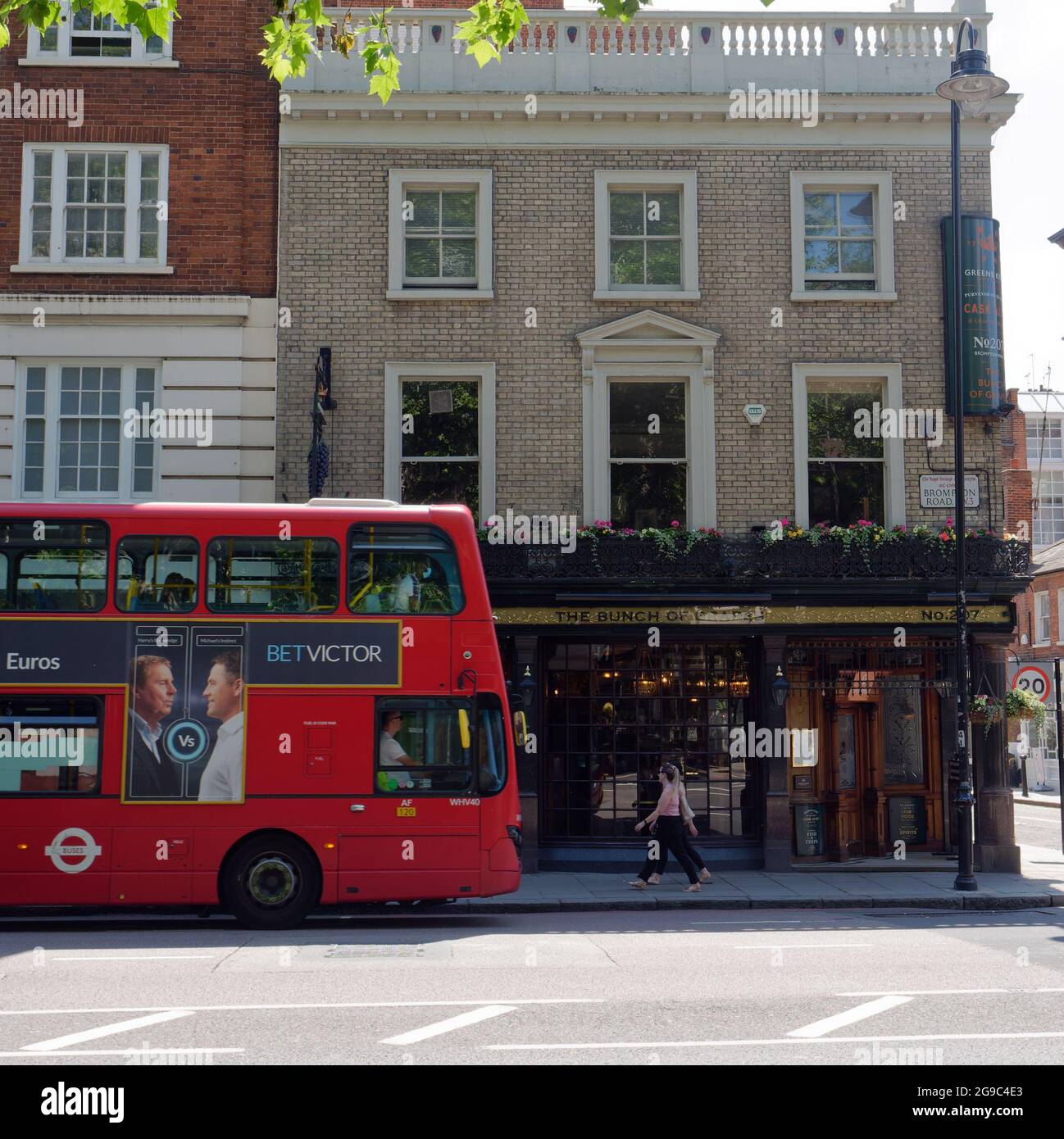 London, Greater London, England, June 12 2021: A bus passes by The Bunch of Grapes pub on Brompton Road in Knightsbridge. Stock Photo