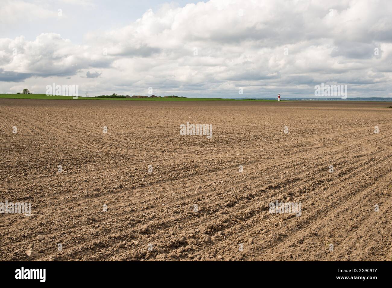 Farmland on the island Ven in Sweden with fresh soil and light house Stock Photo