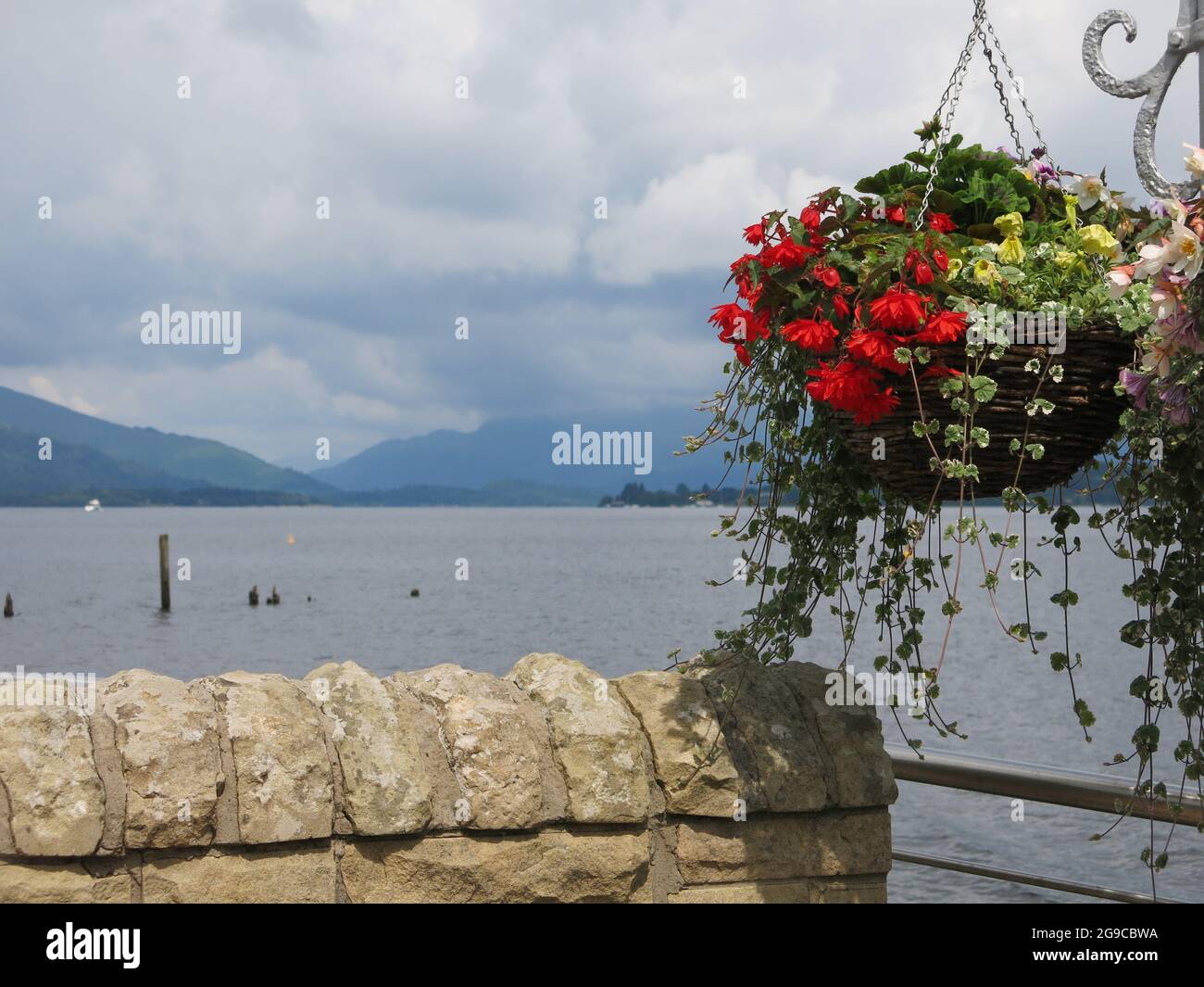 Panoramic views over Loch Lomond from the restaurant at Duck Bay Marina, with hanging baskets along the terrace by the waterfront. Stock Photo